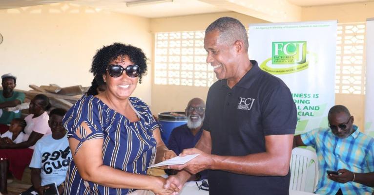Factories Corporation of Jamaica Chairman Lyttleton ‘Tanny’ Shirley (right) presents to Dannette Vickers, a Westmoreland business owner during the handover ceremony on December 17.