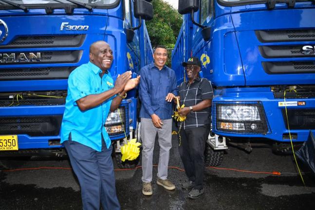 Prime Minister, Dr Andrew Holness (centre); Minister of Local Government and Community Development,  Desmond McKenzie (right); and Executive Director of the National Solid Waste Management Authority (NSWMA), Audley Gordon, celebrate the addition of 10 new 
