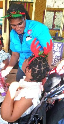 Naudia Crosskill, chief executive officer, St James Municipal Corporation, sharing pleasantries with a female ward at the Mustard Seed Children’s Home in Moore Park, St James at their annual Christmas treat. 
