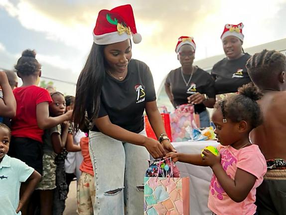 Nickeria Smickle, founder and managing director of A-List Marketing and Entertainment Group, presents a gift bag to a child at the Cooke Street Sports Complex in Westmoreland. The act is part of the company’s ‘Joy to the West’ initiative, aimed at sp
