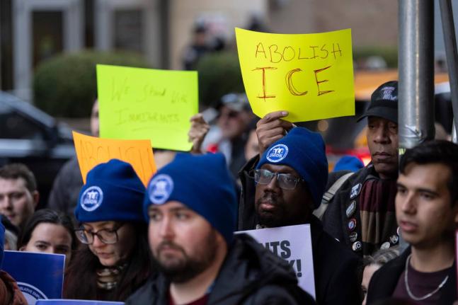 People raise signs in support of immigrants during a news conference outside Greater New York Federal Building, Tuesday, January 13, 2026, in New York. (AP Photo/Yuki Iwamura)