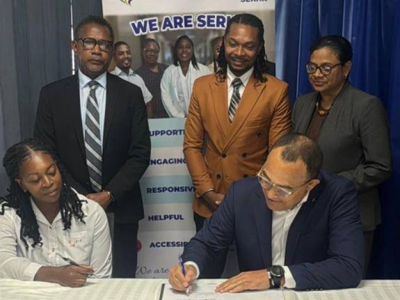 Minister of Health & Wellness, Dr Christopher Tufton and Tasheka Anderson, a parent who will benefit from the Family Caregivers' Pilot Programme sign the caregiver agreement form as the programme is officially launched at the Bustamante Hospital for 