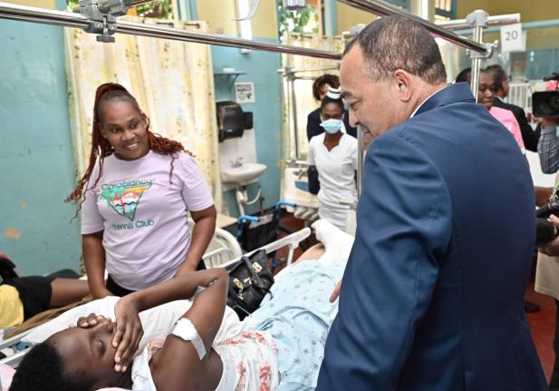Dr Christopher Tufton, minister of health & wellness, speaks with Oshean Noble (left) and her daughter, Tiffany Campbell, during a tour of Ward 1 at the launch of the Family Caregivers Pilot Programme at the Bustamante Hospital for Children on Arthur Wint 