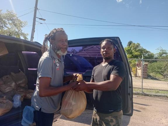 Garth Staple (left), a facilitator at the Violence Prevention Alliance, presents a care package to a fisherman at Rocky Point in Clarendon.