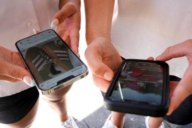 Young people use their phones to view social media in Sydney, November 8, 2024. (AP Photo/Rick Rycroft, File)