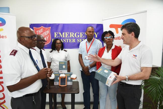 Vincent Daniault (right), managing director, TotalEnergies Jamaica, presents solar-powered lights to Colonel Edwards Lyons (left), chief secretary in charge of Caribbean territories emergency disaster services, Salvation Army, to assist in their hurricane 