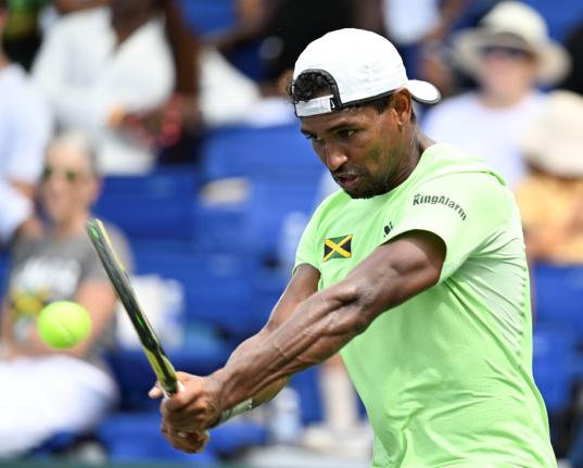 Jamaica’s Rowland Phillips plays a backhanded return during Davis Cup Group II action at the Eric Bell Tennis Centre in 2024.