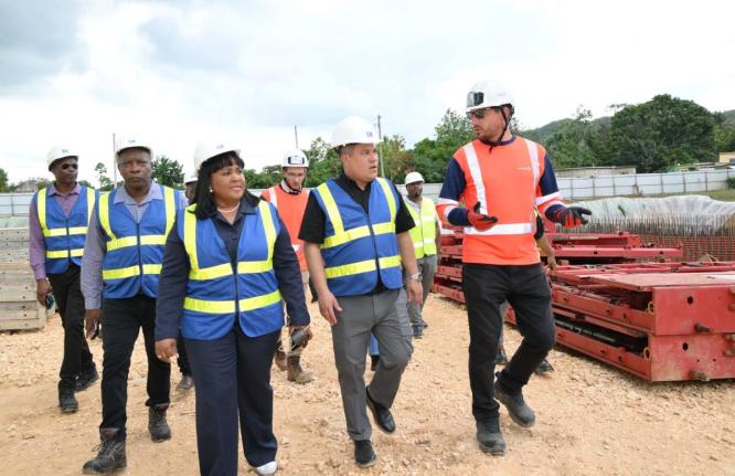 Minister of Water, Environment and Climate Change, Matthew Samuda (centre), along with Member of Parliament for St Catherine North Central, Natalie Neita-Garvey (left), and Project Manager with Vinci Construction, Thomas Savary (right), tour the Rio Cobre 