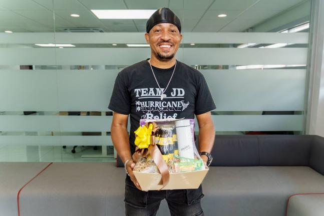 TikTok Creator Manawe Simpson smiles with his gift basket from Malta.