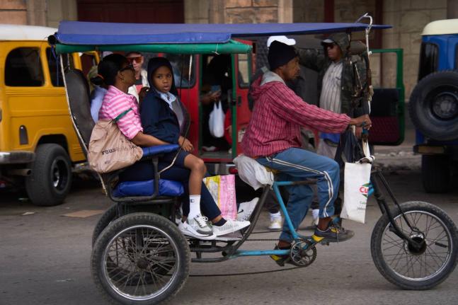 People use a bicycle taxi in Havana, Cuba.