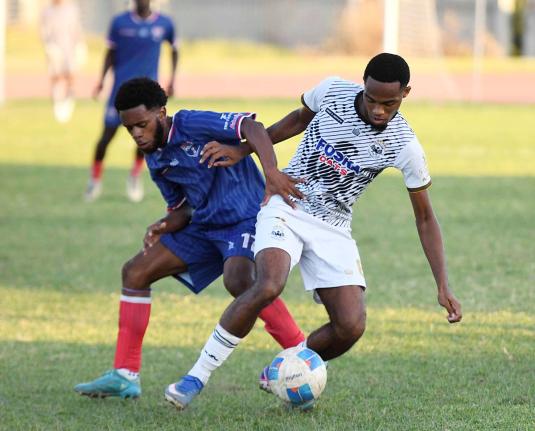 Woto Sports top five player Adrian Reid (right) of Cavalier in action against  Malike Stephens of Spanish Town Police FC during a Jamaica Premier League match at Stadium East on Monday. 