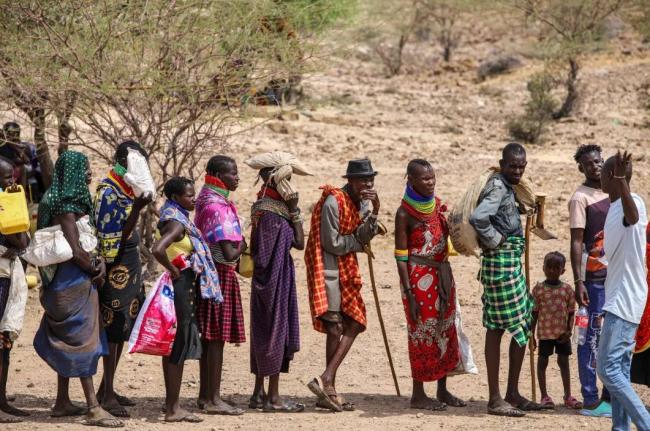 Locals queue to receive relief food as severe drought continues, in Lomekulu Village, Turkana County, Kenya, Sunday, February 8, 2026. 