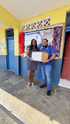 Hakeem Atkinson (right), member relations supervisor at the Jamaica National Group, presents books to Thamar Russell-Brown, acting principal at the Allman Town Primary School. The donation was presented to the school following a book drive organised by the