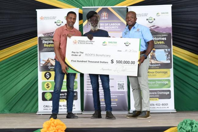 Chensie Allen (centre) accepting a symbolic cheque valued at $500,000 from the Ministry of Labour and Social Security’s ROOFS Programme. Presenting the cheque were Dwayne Vaz, member of parliament for Westmoreland Central (left), and Pearnell Charles Jr,