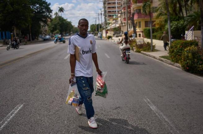 State-run bodega manager Roberto Roman carries bags of donated Mexican humanitarian assistance to be delivered to a family in Havana, Cuba, Thursday, February 19, 2026. 