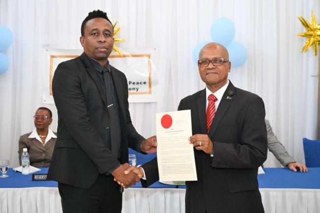 Custos Rotulorum for Portland, Lincoln Thaxter (right), presents Councillor Rohan Vassell with his Instrument of Appointment during the commissioning ceremony for 28 new justices of the peace (JPs), held at Hotel Tim Bamboo in Port Antonio on February 19, 