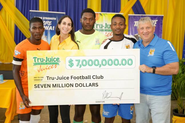 Lauren Mahfood (second left), marketing manager at Trade Winds Citrus Limited, and Peter McConnell (right), managing director of Trade Winds Citrus Limited, share a moment with members of the Tru-Juice Football Club following the formal handover of a $7-mi