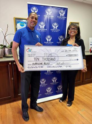  Robin Levy, Group CEO of JCCUL (left), accepts a US$10,000 donation from Judy James, board member of  We Florida Financial Credit Union, to assist Jamaican credit union employees with hurricane recovery efforts. The handover took place on February 20.
