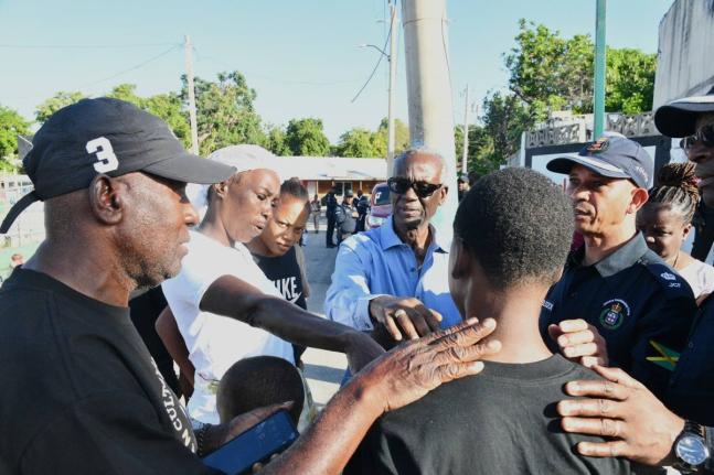 Minister of Local Government and Community Development and Member of Parliament for West Kingston,Desmond McKenzie (centre), offers words of comfort to Jayce Pinnock's mother, Ladania Cunningham (second left) and other relatives, during a visit with the fa