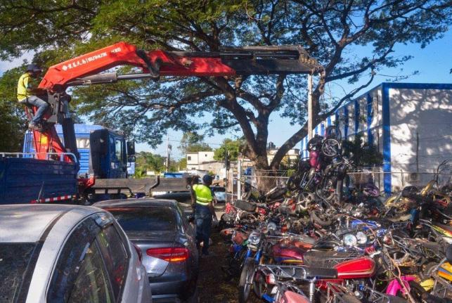 Heavy equipment is being used to remove unclaimed, derelict bicycles and motorbikes on the grounds of the Constant Spring Police Station in St. Andrew during a clean-up day at the facility on February 21.