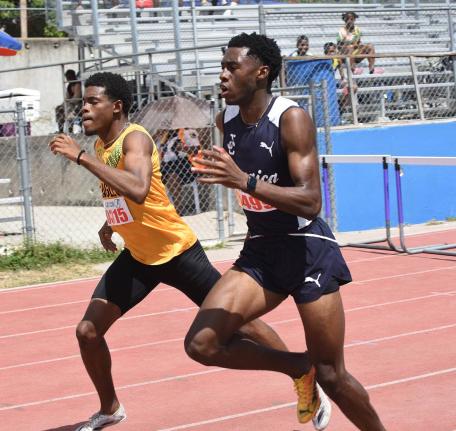Rojay Black (right) of Jamaica College and Excelsior High’s Kishawn  Hoffman in a close battle during heat one of the Class One boys 400m hurdles on day one of the Corporate Area Athletics Championships at Ashenheim Stadium last Friday. Black won in 51.4