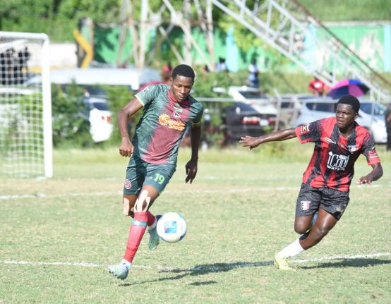 Montego Bay United’s Philando Wing (left) tries to outrun Arnett Garden’s Ranoldo Lawrence during their Jamaica Premier League game at Jarrett Park in Montego Bay yesterday.