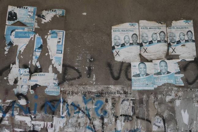 Old campaign posters from the 2016 presidential election cover a wall along a sidewalk in Port-au-Prince, Haiti, Monday, March 2, 2026. (AP Photo/Odelyn Joseph)