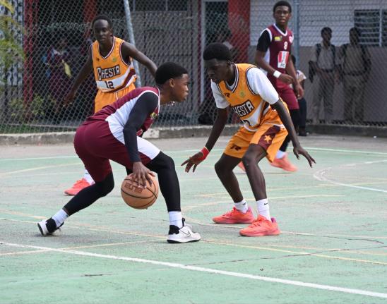 Herbert Morrison Technical High’s Antonio Kerr (left) tries to dribble around Manchester High’s Wasim Windett during Game One of the ISSA Schoolboy Under-16 Basketball finals at Herbert Morrison’s court on Monday.