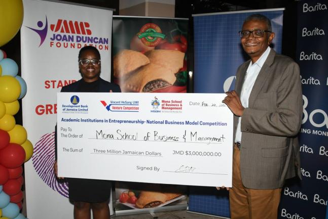 Dr David McBean, executive director of the Mona School of Business and Management (right), and Deidre-Ann Burrell, Programme Officer at the Development Bank of Jamaica, mark DBJ’s $3 million commitment to the Vincent HoSang UWI Venture Competition, a par