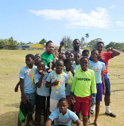 Spanish Town Primary School’s principal Roogae Kirlew (left, back row), coach Neriah Barrett (centre, back row) celebrate with the players after their 1-0 win over Old Harbour in the Insports St Catherine Primary Schools football final. Spanish Town won 