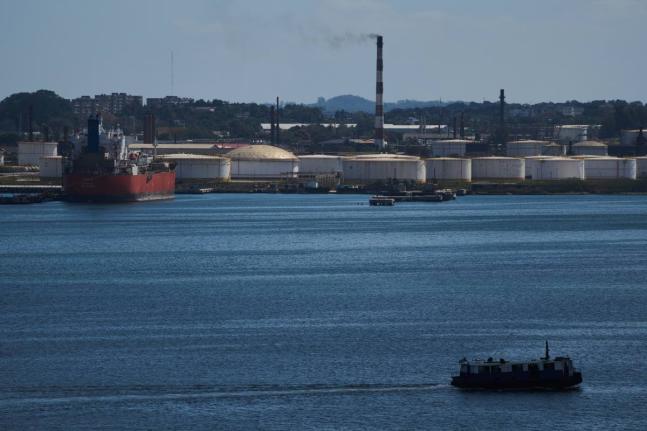 A ferry crosses Havana Bay past the Nico Lopez oil refinery where a Cuban tanker is anchored in Havana, Cuba, Thursday, February 26, 2026. (AP Photo/Ramon Espinosa)