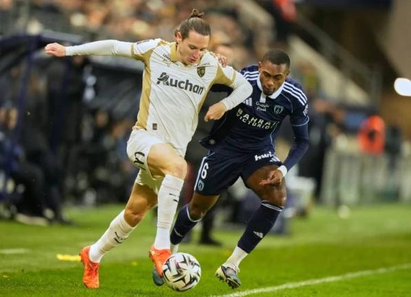 Lens’ Florian Thauvinl (left) dribbles away from Paris’ Otavio Ataide Da Silva during the French League One match against Paris FC in Paris on Saturday, February 14.