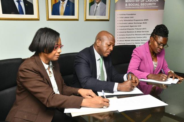 Minister of Labour and Social Security, Pearnel Charles Jr., is joined by Acting Permanent Secretary, Dione Jennings (left), and President of the Jamaica Household Workers Union (JHWU), Elaine Duncan, in signing a Memorandum of Understanding (MOU) at the M