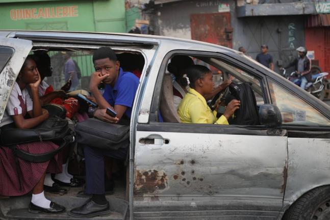 Passengers ride in a shared taxi as it makes its way through Port-au-Prince, Haiti on March 25.