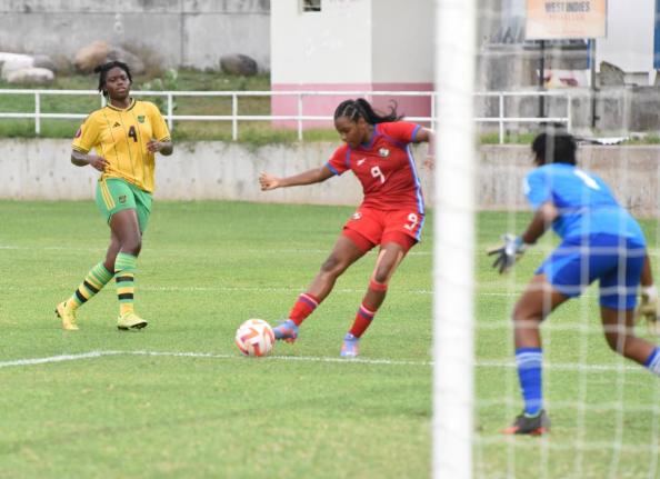 Reggae Girl Shanae Ashley (left) looks on as Panama’s Analia Arosemena (centre) shoots toward Jamaican goalkeeper, Sajane Anderson, during an Under-17 game earlier this year.