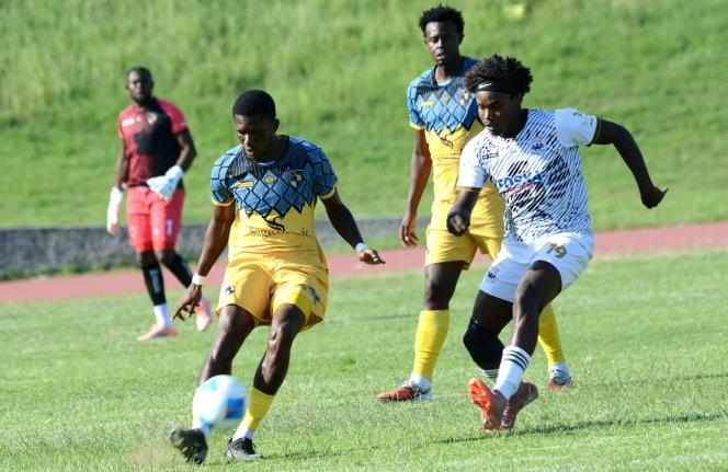 Jimoy Jones (left) of Racing United shields the ball from Cavalier’s Chad James during yesterday’s Jamaica Premier League match at the Stadium East field. Cavalier won 2-0. 