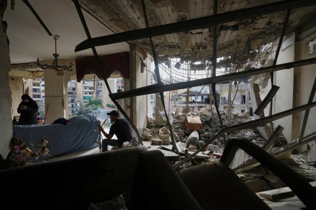 Fadi Al Zein, who lost both his homes in Israeli strikes in his village of Khiam and in Dahiyeh, smokes a water pipe inside his heavily damaged home in Beirut’s southern suburbs of Lebanon.