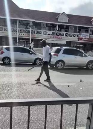 A screen grab of the man in the video walking along the busy Half-Way-Tree, St Andrew, thoroughfare smashing vehicles with what appears to be a machete early Tuesday morning.