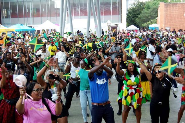 Jamaicans and friends of Jamaica wave the Jamaican flag during JAMAICA Fest 2025, hosted by the Embassy of Jamaica at Veterans Plaza in downtown Silver Spring, Maryland.