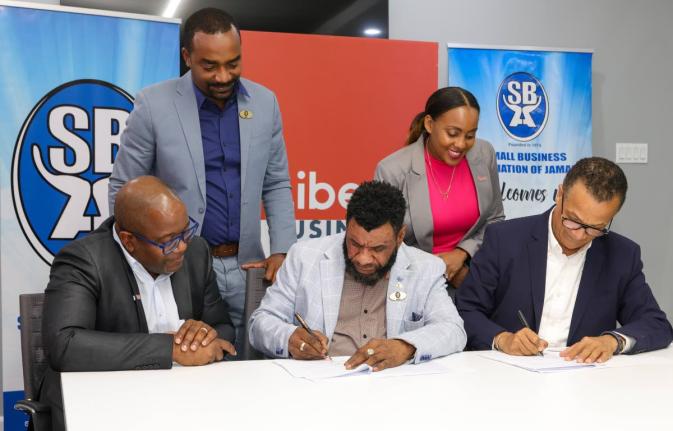 Garnet Reid (centre), president of the Small Business Association of Jamaica, and Charles Manus (right), senior director of Liberty Business, sign a memorandum of understanding to provide digital solutions supporting the growth of small businesses. Sharing