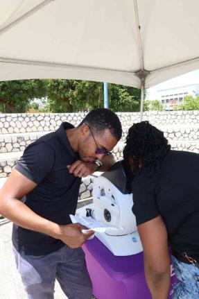 Carlington Willis, general manager of Eye Q Optical, provides a free eye examination as part of the vision screening services offered at the Kingston Public Hospital 250th Anniversary Health and Wellness Fair. 