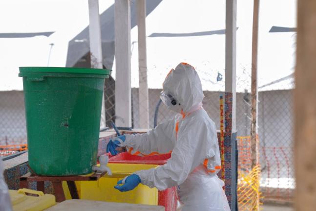 A health worker in protective gear washes her hands at the treatment centre in Bunia General Hospital in Ituri, eastern Congo, on Tuesday.