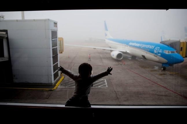 A child watches a plane at the Jorge Newbery Airport in Buenos Aires, Argentina, April 14, 2016. 