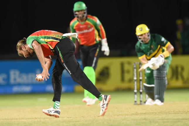 Guyana Amazon Warriors captain Imran Tahir (left) takes a return catch to dismiss Jamaica Kingsmen batter Reeza Hendricks (right) during their Caribbean Premier League T/20 Cricket match at Sabina Park on Thursday. Looking on is Amazon Warriors’ wicketke