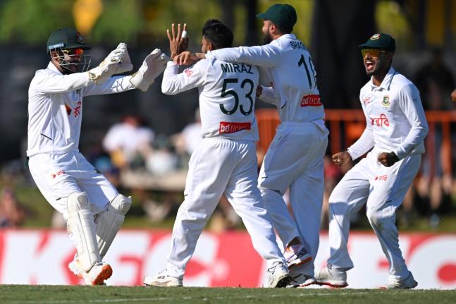 
Mehidy Hasan Miraz (centre) of Bangladesh is congratulated by teammates after taking the wicket of Australia’s Steve Smith during play on day three of the first cricket Test in Darwin, Australia, yesterday.