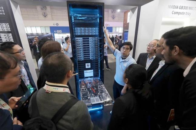 Visitors listen to the introduction o NVIDIA GB300 NVL72 AI server during the Hon Hai Tech Day in Taipei, Taiwan, November 21, 2025.