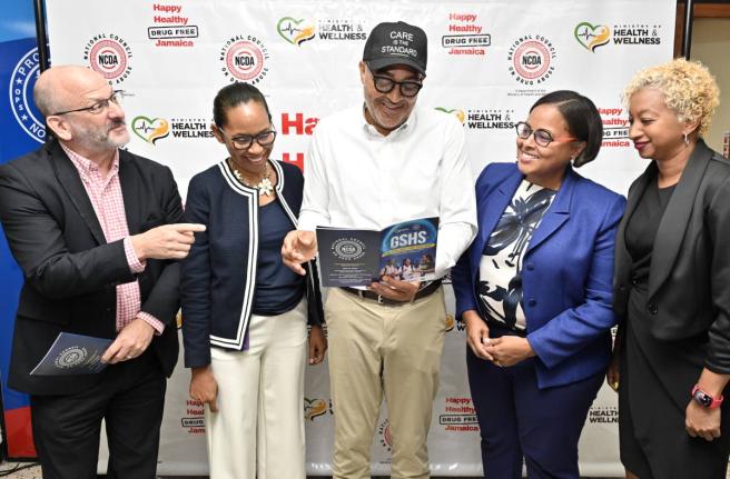 Dr Christopher Tufton (centre), minister of health and wellness, examines the Global School-Based Student Health Survey report while in discussion with (from left) Ian Stein, PAHO/WHO representative to Jamaica, Bermuda and The Cayman Islands; Paulette Smit