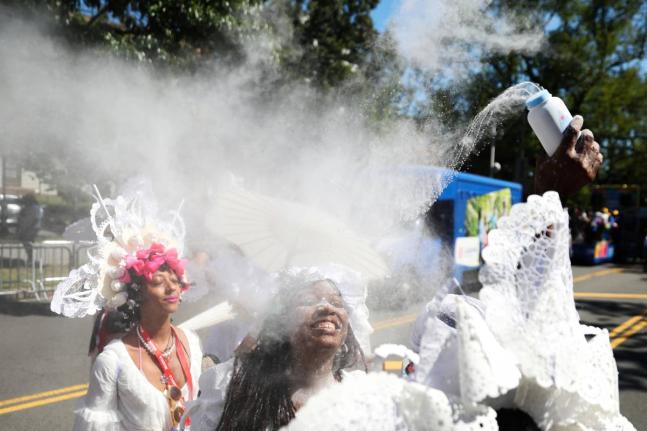 Members of the Belmont Baby Dolls throw baby powder as they wait for the start of the West Indian American Day Parade in the Brooklyn borough of New York on Monday. - AP photo