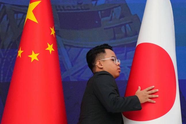 Staff organise flags from China, left, and Japan before the start of the 28th ASEAN Plus Three Summit in Kuala Lumpur, Malaysia, on October 27, 2025. 