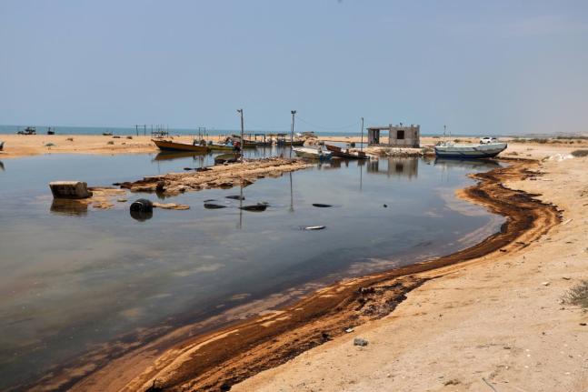 Oil residue lines the shore near fishing boats on Qeshm Island, Iran, amid ongoing wartime attacks on vessels and infrastructure in and around the Strait of Hormuz, though the spill's source has not been independently determined. - AP photo